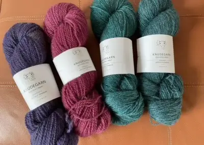 Vier Stränge Knudegarn reine Wolle in den kräftigen Farben Violett, Dunkelrosa und 2x Türkisgrün