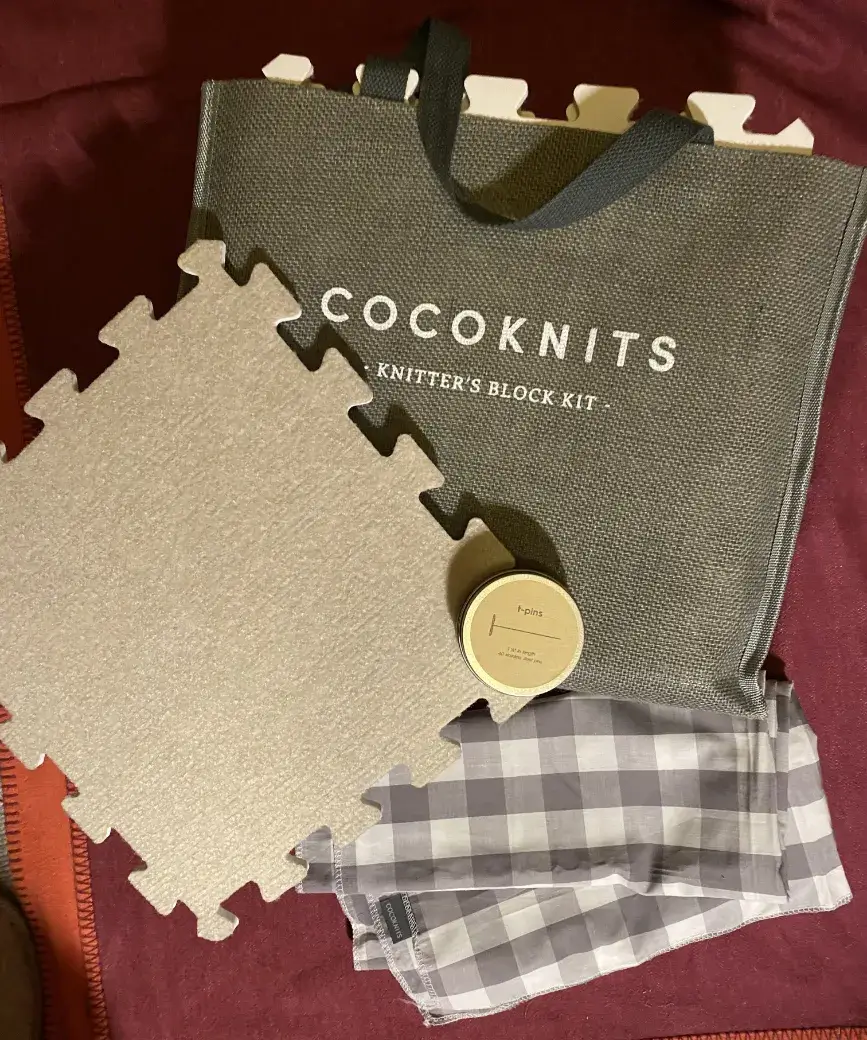 Das Spann-Set von cocoknits mit Spann-Platten, T-Pins und Karo-Tuch in der Tragetasche aus Jute Das Spann-Set von cocoknits mit Spann-Platten, T-Pins und Karo-Tuch in einer Jutetasche